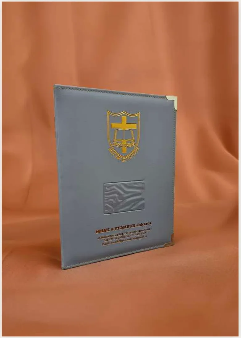 Sampul rapor jahit abu-abu SMAK 6 Penabur Jakarta dengan logo emas